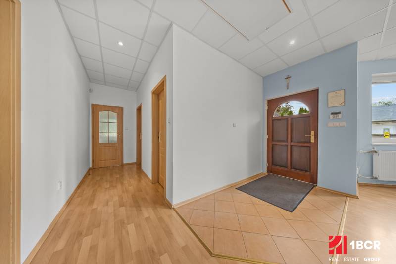 A hallway in a family house with wooden floors, doors, and entry elements.