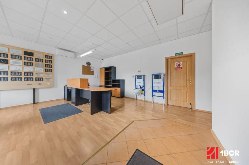 Office space in a family house with wooden flooring, a desk, and shelves.
