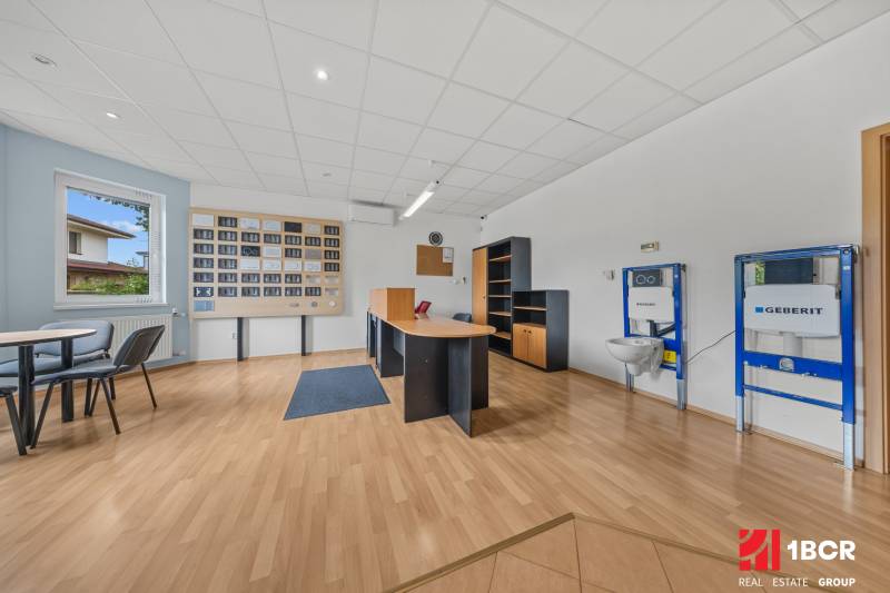 Office in a family house with a desk, chairs, and sanitary fixtures on the wall.