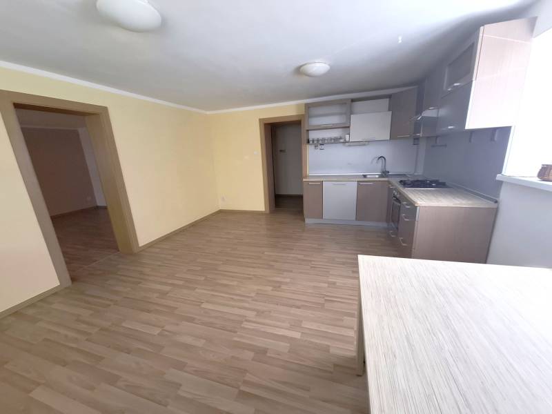 A kitchen in a 4-room apartment with a light floor and wooden furniture.