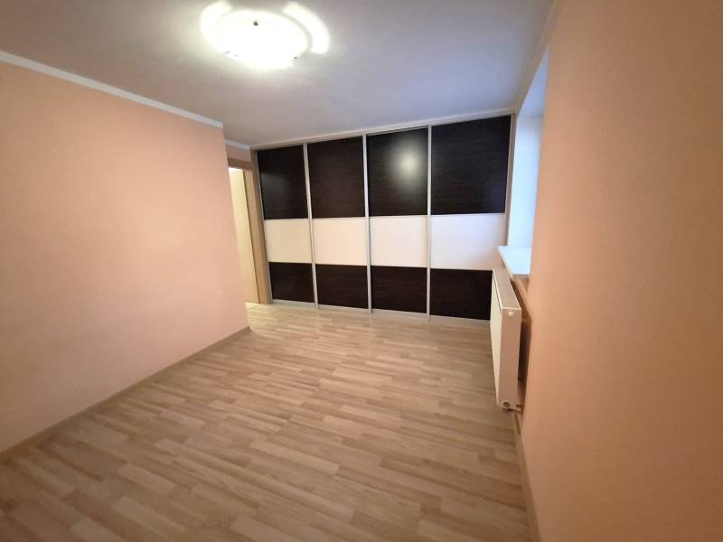A room in a 4-room apartment with laminate flooring and a built-in wardrobe.