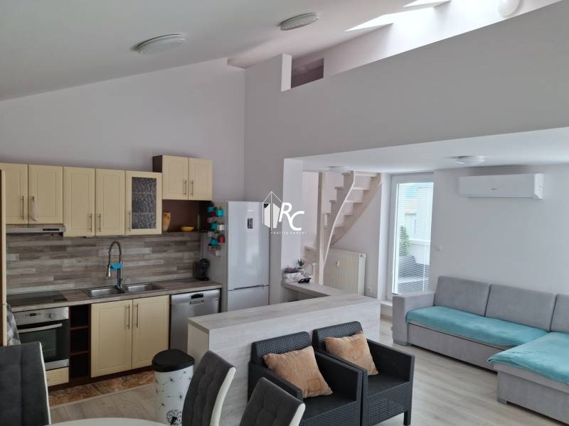 Living room with kitchen, sofa, and stairs in a 4-room apartment.