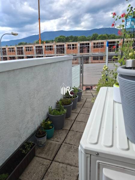 A terrace with garden planters and a view of a 4-room apartment under construction in Martin.