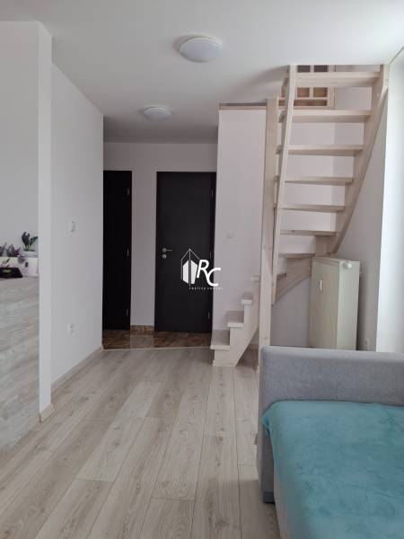 Interior of a 4-room apartment with light floors, staircase, and doors.