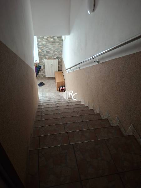 Staircase in a 4-room apartment, tiles and railing, hallway with radiator.
