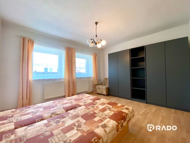 Bedroom with a built-in wardrobe, double bed, and an armchair in a 2-room apartment.