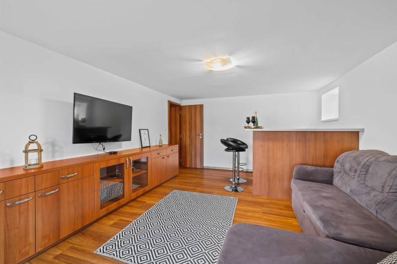 The photograph shows a cozy living room in a family house with wooden flooring.