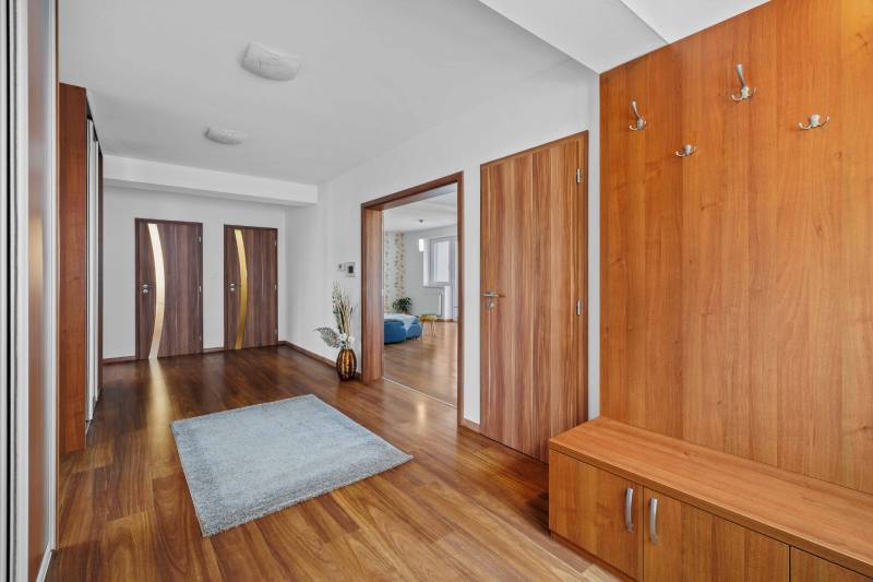 A spacious hall with wooden furniture on Pluhová Street, entrance to a family house.