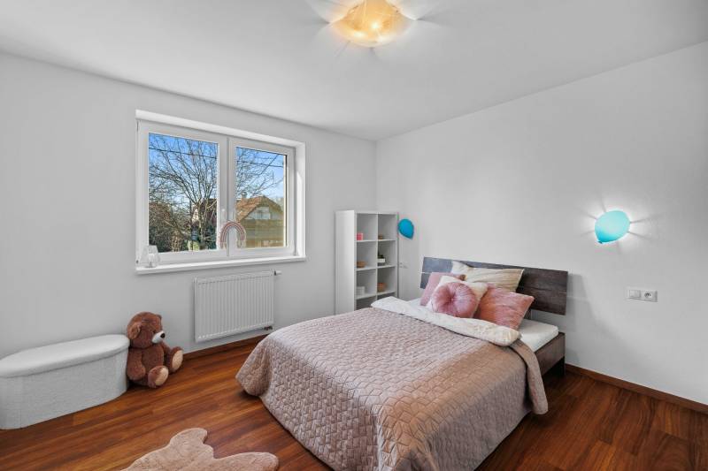 Children's room on Pluhova Street, family house, wooden floor, bed, plush bear.