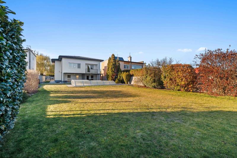 A family house with a swimming pool, a well-maintained lawn on Pluhová Street, surrounded by greenery.
