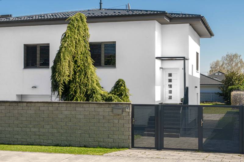A family house on Pluhova Street in Ivanka pri Dunaji with a modern fence and greenery.