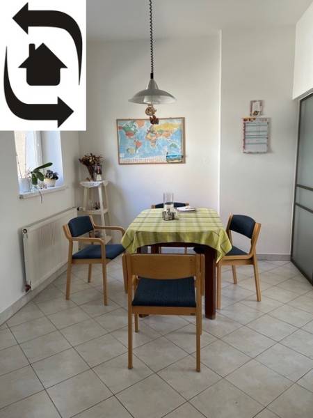 Dining area in a 5 or more room apartment with a table, map, and wooden chairs.