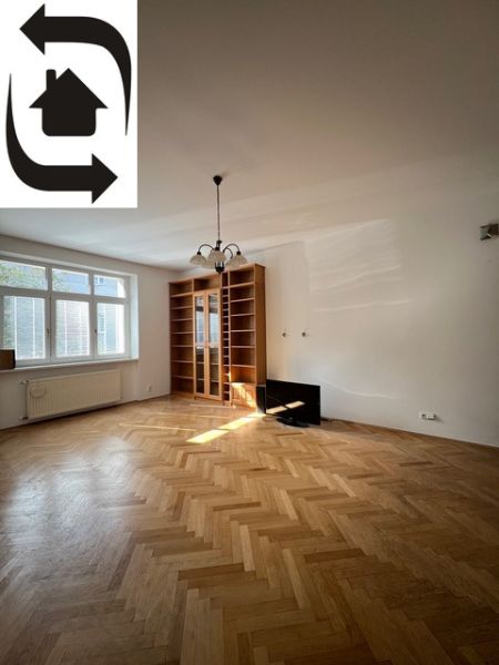 A spacious living room with a wood-patterned floor in a 5 or more room apartment.
