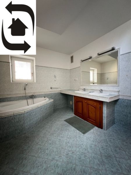 A bathroom in a 5 or more room apartment with a corner bathtub and double sink.