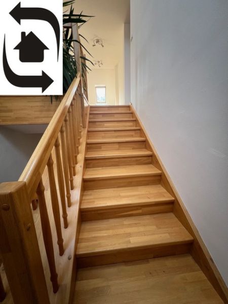 A staircase with a wooden decor leads to the upper floor in a 5 or more room apartment.