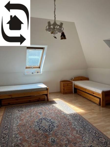A bedroom with two beds and a carpet in a 5 or more room apartment.