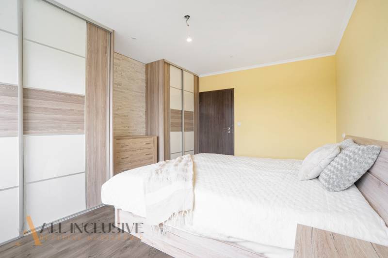 Bright bedroom with a wooden bed and a built-in wardrobe in a 3-room apartment.