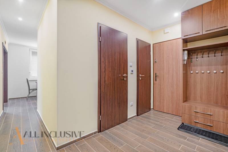 Entrance hallway with wooden doors and flooring in a 3-room apartment.