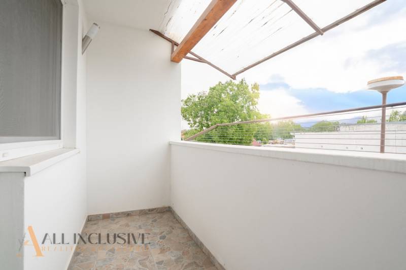 The balcony of a 3-room apartment in Gabčíkovo with a view of the surrounding trees and buildings.