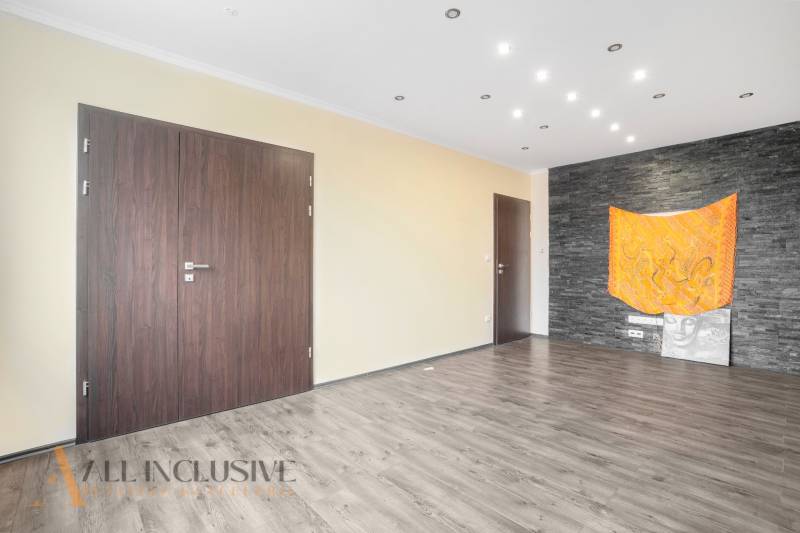 Interior of a 3-room apartment with wooden floors, dark doors, and a black wall.