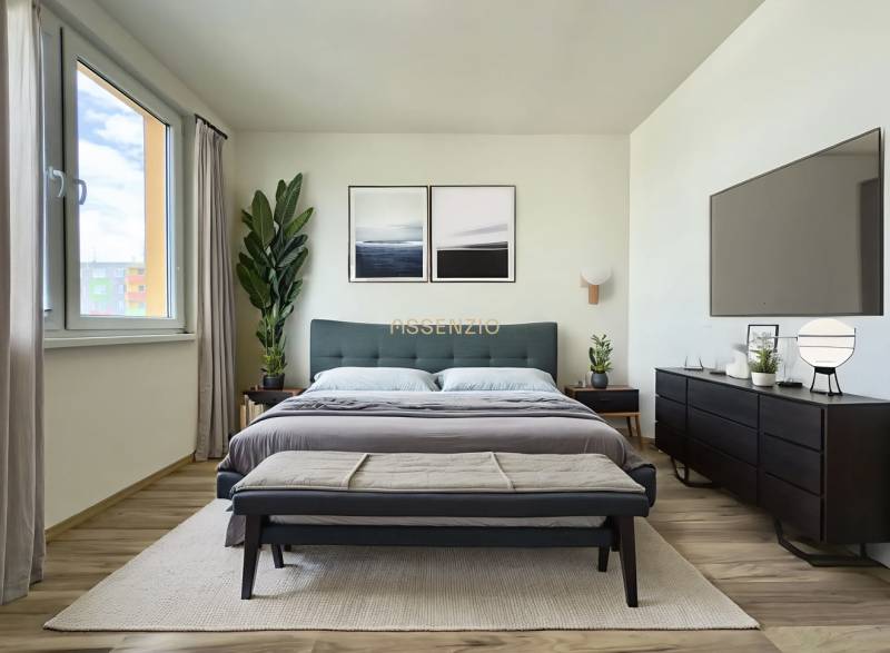 A bright bedroom in a 3-room apartment with a large bed, plants, and minimalist furniture.