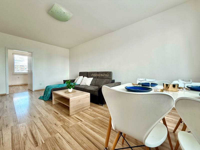 Living room in a 3-room apartment with a sofa, table, and set dining area.