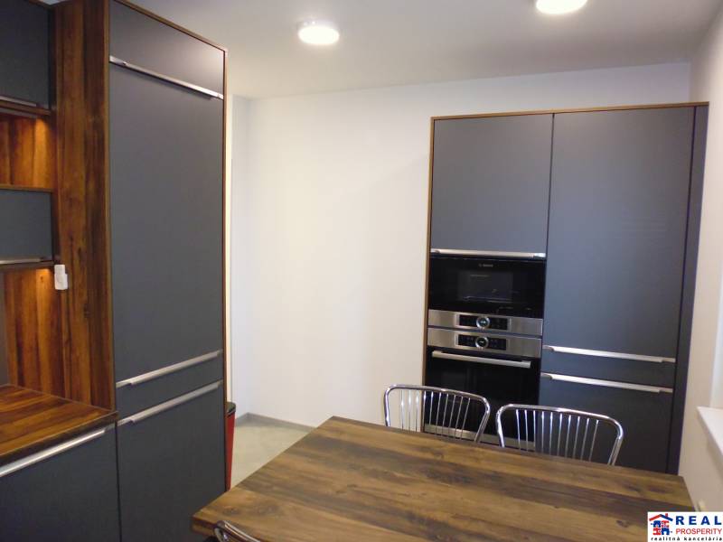A kitchen in a 3-room apartment with wooden and metal elements.