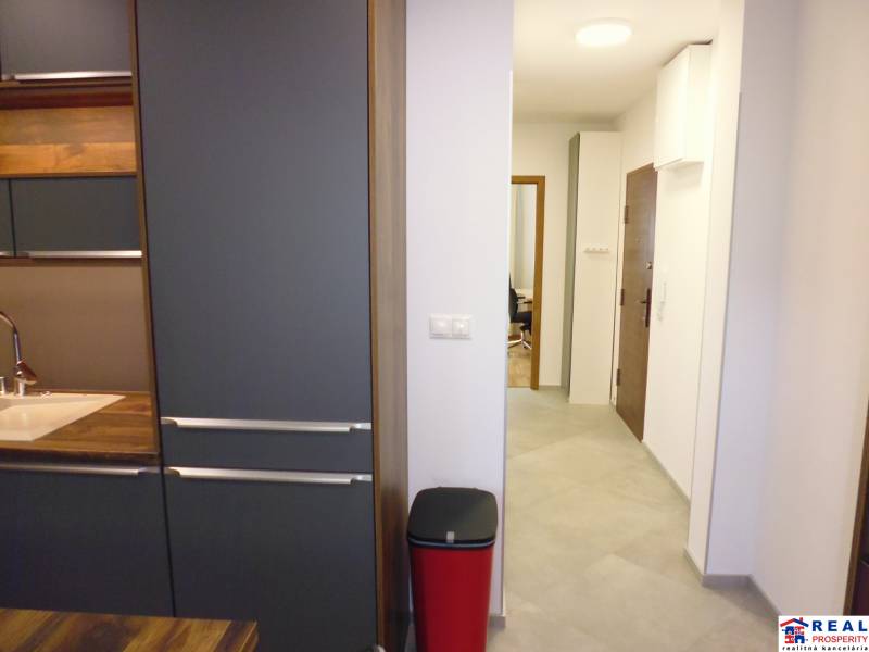 A kitchen unit in a 3-room apartment with black and wooden elements.