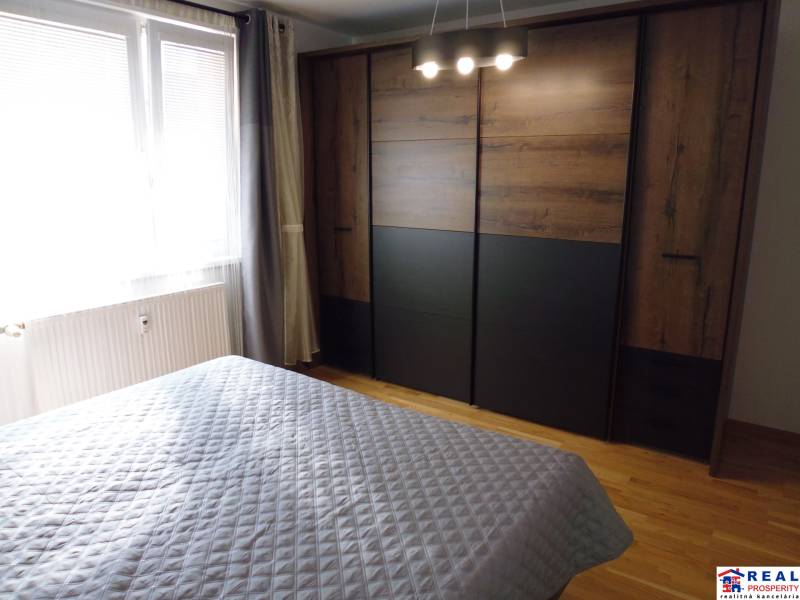A bedroom with a bed, a window, and a built-in wardrobe in a 3-room apartment.