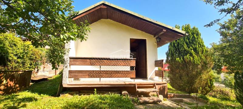 A cottage in Mojš surrounded by greenery, with a terrace and stairs in a natural setting.