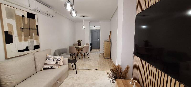 Bright living room with a sofa, table, and modern decor in a 3-room apartment.
