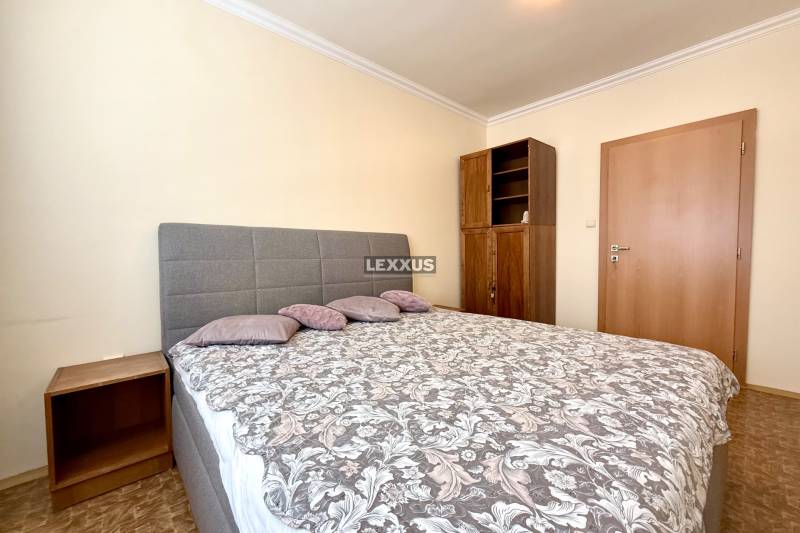 A bedroom with a double bed and a wooden wardrobe in a 3-room apartment.