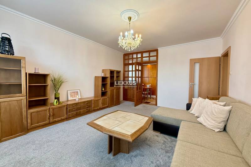 Living room in a 3-room apartment with wooden furniture and a sofa, pleasant atmosphere.