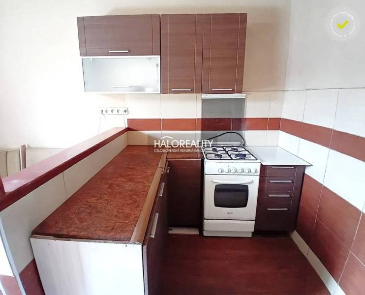 Kitchen with a sink, stove, and sofa in a family house.