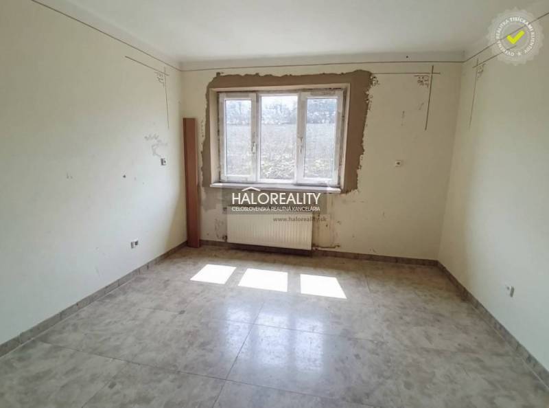A hallway in a family house with orange walls and checkered tiles.