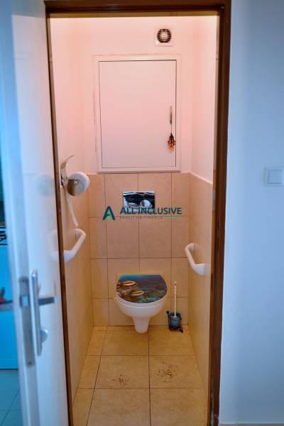 A bathroom with tiles and a decorative cover in a 3-room apartment.