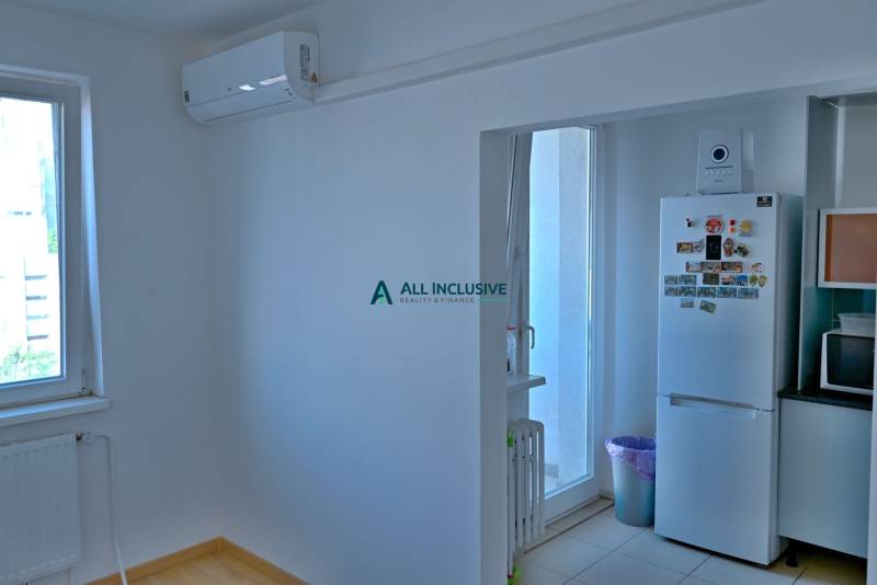 A kitchen in a 3-room apartment with air conditioning, a refrigerator, and a microwave.