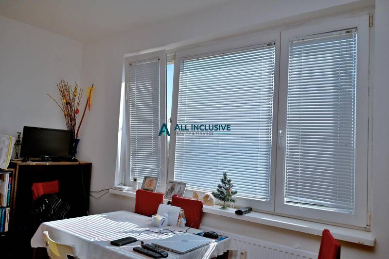 A bright room with large windows and a table in a 3-room apartment.