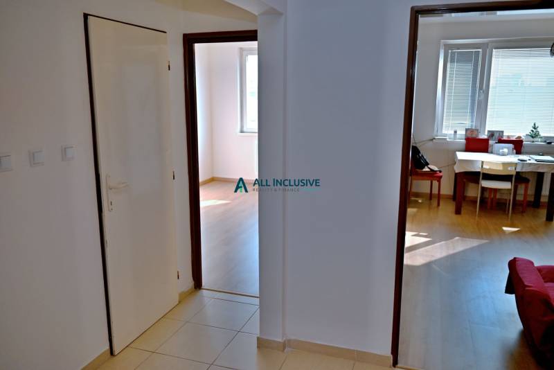 A hallway in a 3-room apartment with a view of the dining room and a room.