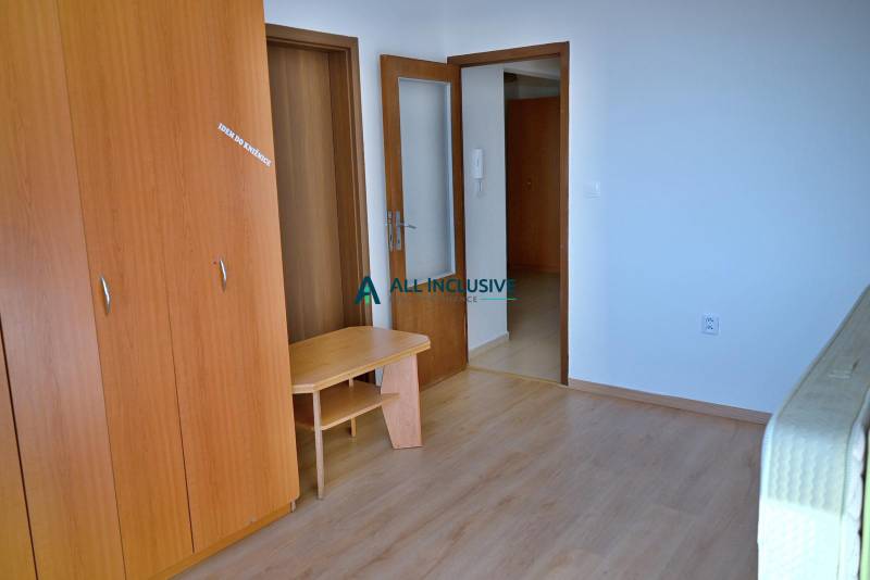 Interior of a 3-room apartment with a wooden wardrobe and open doors.