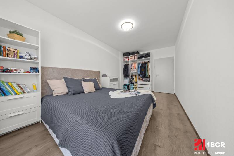 Master bedroom with a built-in wardrobe and a bookshelf in a 2-room apartment.