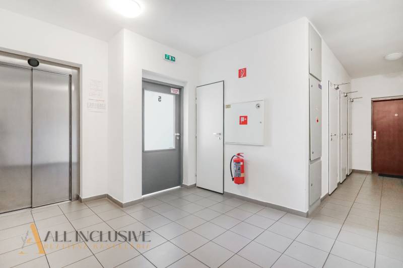 Hallway with elevator and emergency exit in a 2-room apartment.