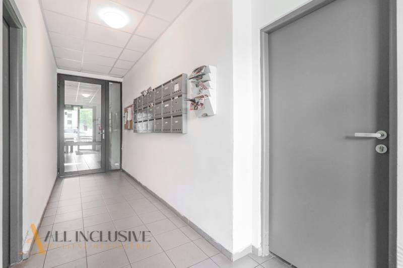 Hallway with mailboxes and doors in a 2-room apartment, bright atmosphere.