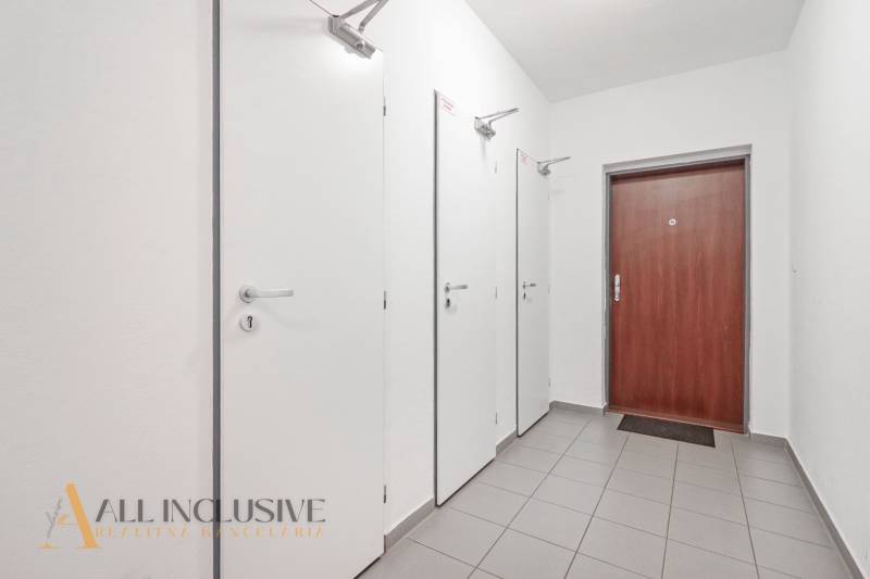 A hallway with four doors and modern tiles in a 2-room apartment.