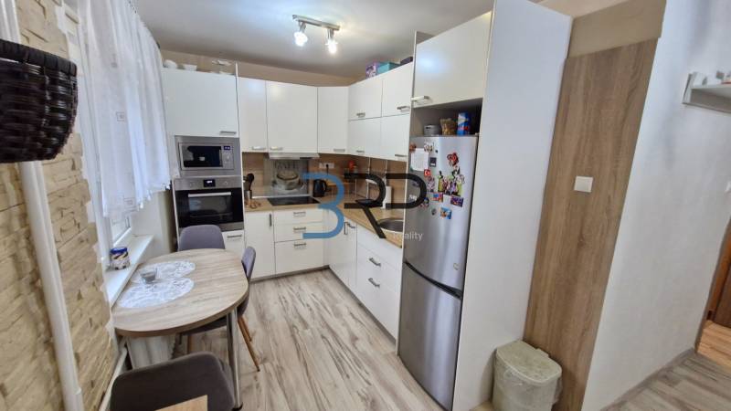 A kitchen in a 3-room apartment, light kitchen unit with equipment, wooden floor.