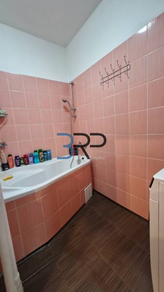 A bathroom with a bathtub and orange tiles in a 3-room apartment.