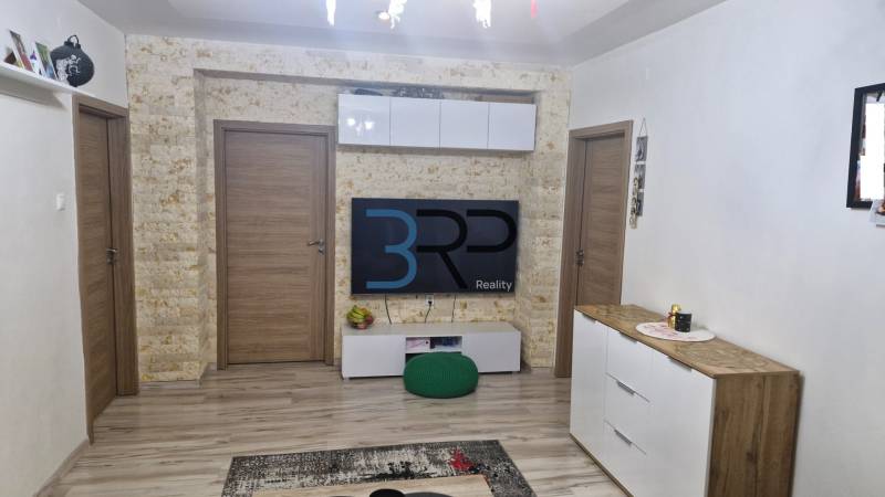 Living room with decorative stone, wooden doors and furniture, 3-room apartment.