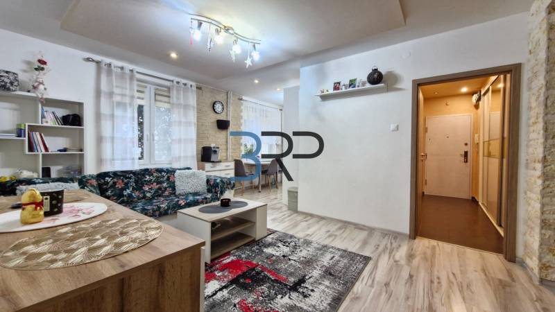 Living room in a 3-room apartment with a comfortable sofa, modern curtains, and a dining table.