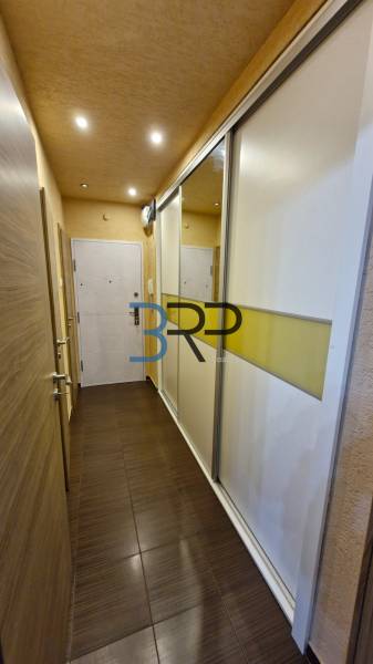 A narrow hallway with a sliding wardrobe; entrance to a 3-room apartment.