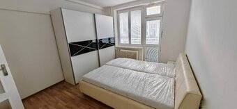 Bedroom with a double bed and a large wardrobe in a 2-room apartment. Verified member of the real estate association.
